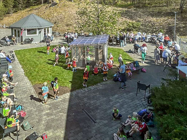 Oversikt over hagen på Lagård med flere eldre sammen med barnehagebarn