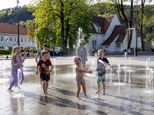 Barn og bader i fontenen på torget