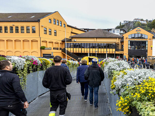 Folk som går over broen til kjøpesenteret Eikunda