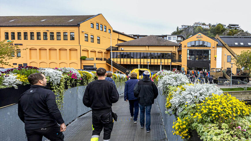Folk som går over broen til kjøpesenteret Eikunda