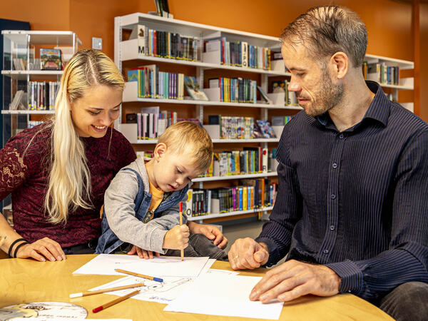 En familie som er på besøk til biblioteket