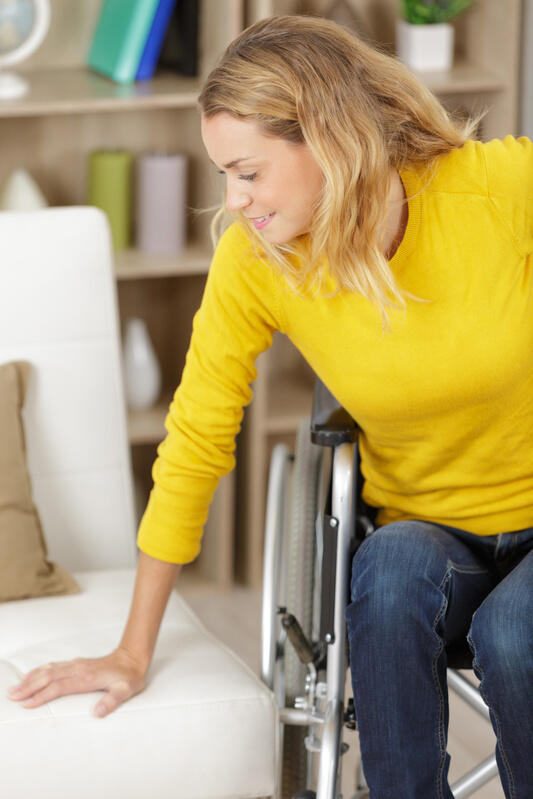 mp62289693-woman-transferring-herself-from-the-wheelchair-to-the-sofa