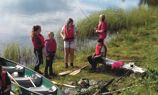 Barn ved fiskevann, kano og fiskestenger