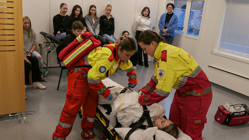 Amulansearbeidere som øver forran et ungt publikum