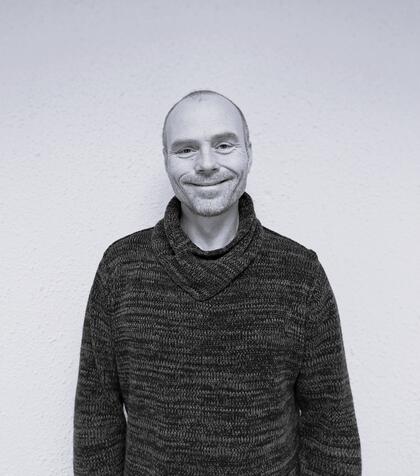 Sort/hvitt bilde av smilende mann