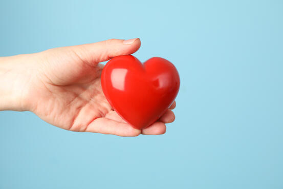 mp38290617-female-hand-holds-heart-on-blue-background-health-care