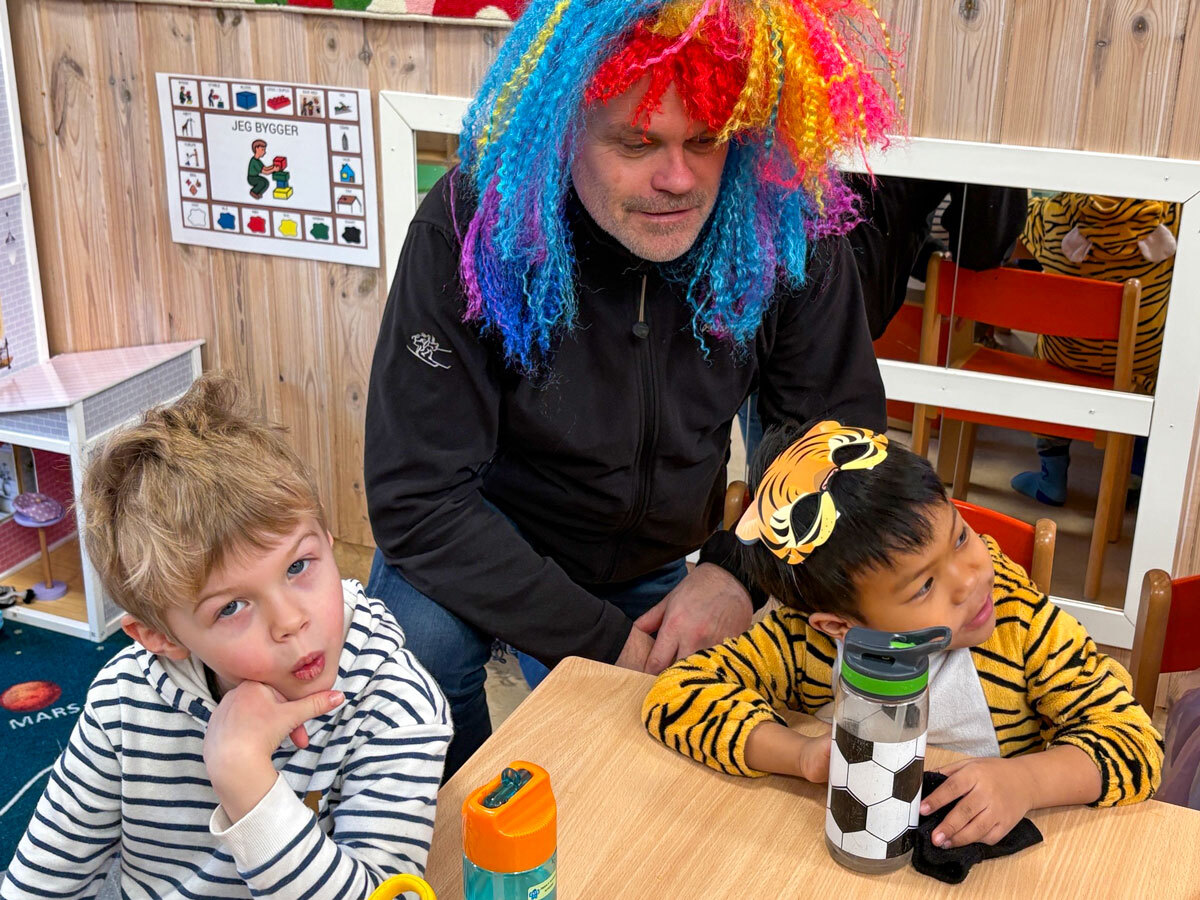 God stemning rundt bordet i barnehagen med en voksen og flere barn