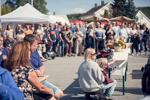 publikum som står og sitter på markedsplass