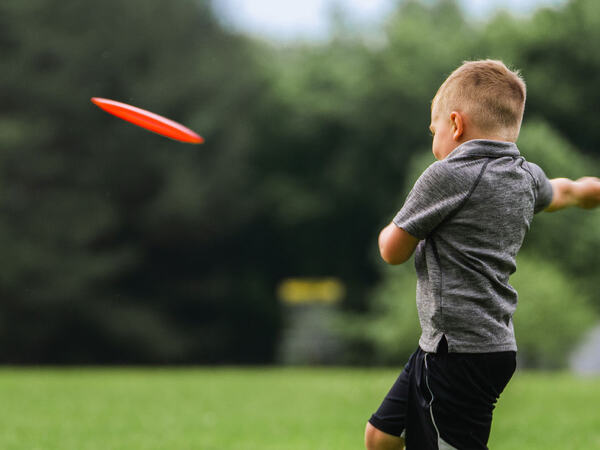 Gutt som spiller frisbeegolf