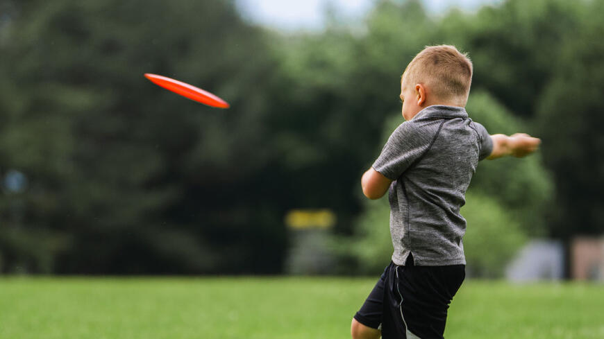 Gutt som spiller frisbeegolf