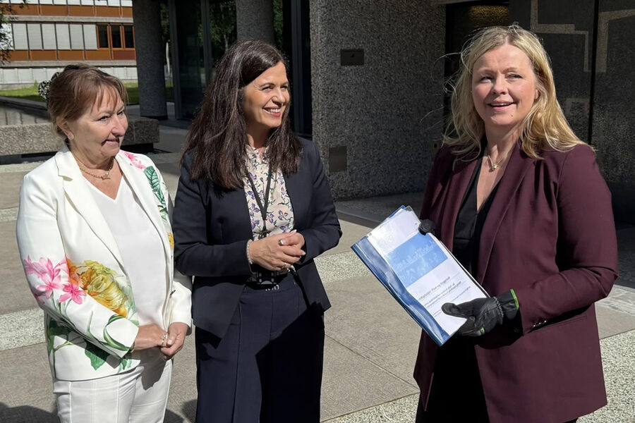 Styreleder i KS, Gunn Marit Helgesen og adm. direktør i NHO Byggenæringen, Nina Solli overrekker bruttolisten til Kommunal- og distriktsminister Kjersti Stenseng. Hun har også fått et par arbeidshansker, som symbol på at det er nå den politiske jobben begynner. Foto: NHO Byggenæringen