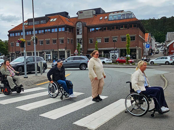 Ordfører med flere ruller i rullestol over et gangfelt