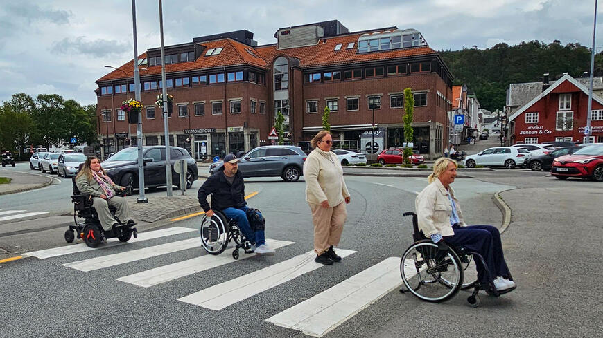 Ordfører med flere ruller i rullestol over et gangfelt