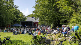 Publikum ser på en utekonsert i maurholen i fint vær