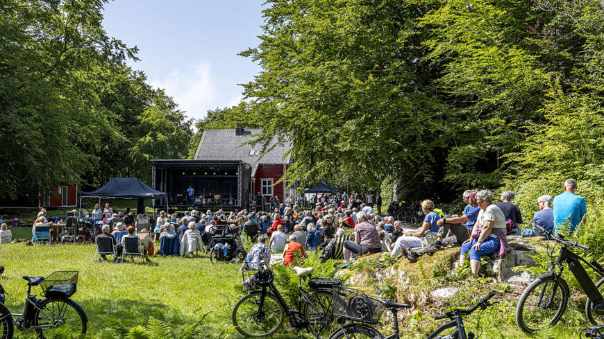 Publikum ser på en utekonsert i maurholen i fint vær