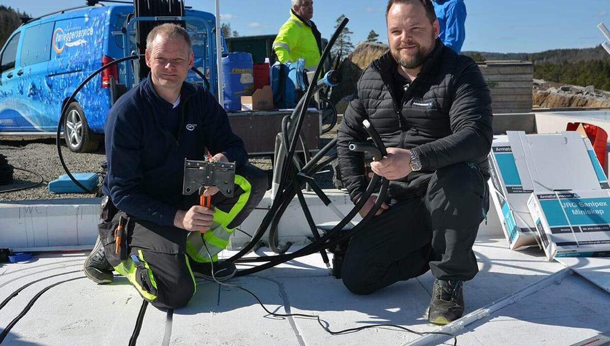Asbjørn Rugnes i Vegårshei Rørleggerservice (t.v), og distriktsansvarlig Marius Ellefsen i Armaturjonsson. på et prosjekt i Vegårshei. Her viser de frem EL-kniven som freser ut sporene til rørene i isoporen. Dette verktøyet har blitt noe av Asbjørn sitt varemerke i bransjen, og Armaturjonsson har videreutviklet produktet.