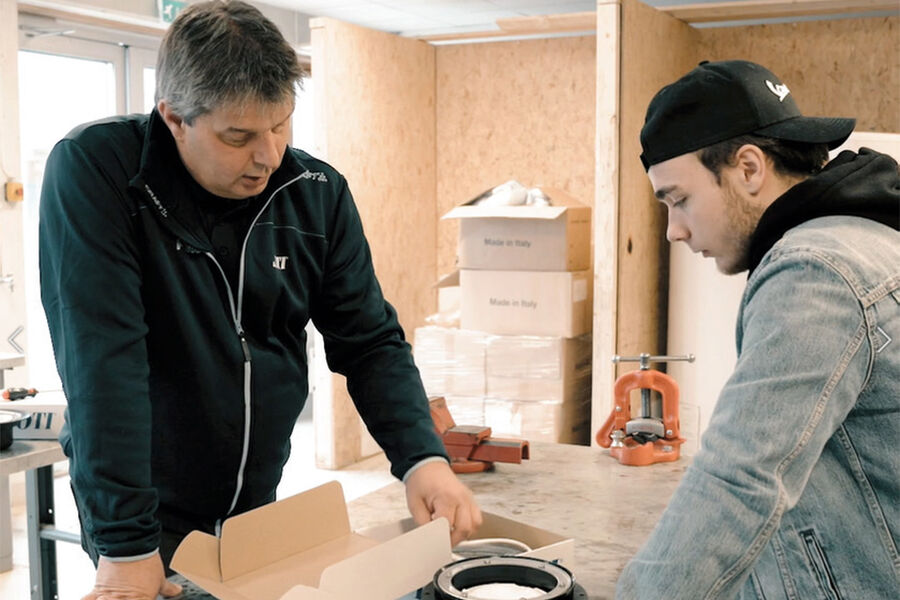 Tommy Leiren i sitt rette element sammen med en ung rørleggere som ønsker mer kunnskap om sluk og installasjoner. Opplæring og kunnskapsformidling er noe Leuen virkelig brenner for.