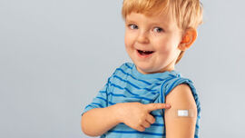 En liten gutt som har fått plaster på armen etter å ha tatt vaksine