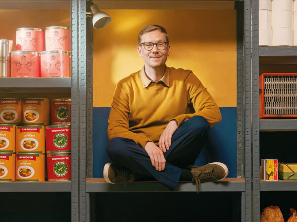 En person som sitter i en hylle sammen med matvarer