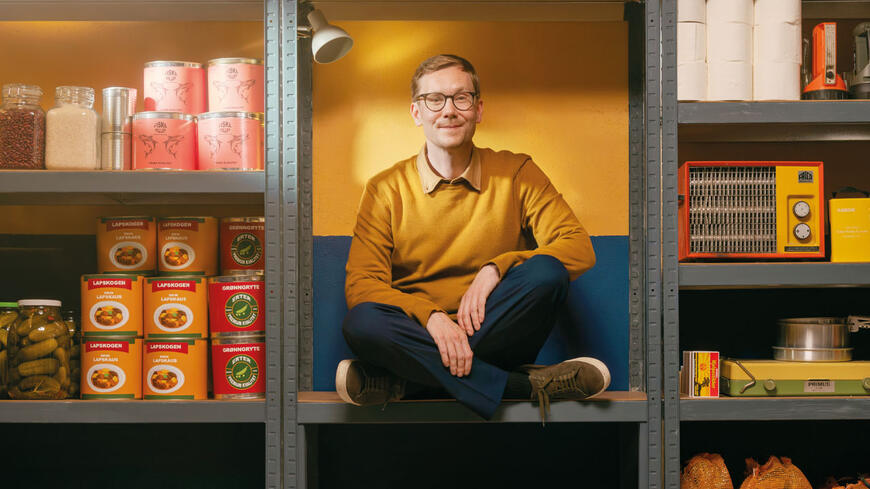 En person som sitter i en hylle sammen med matvarer