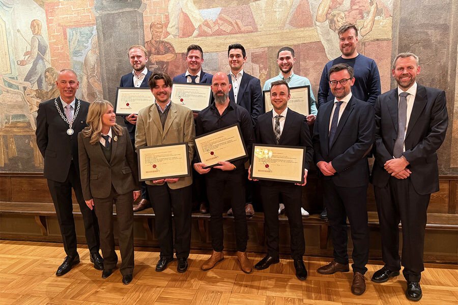 På bildet ser vi alle de 8 nye rørleggermesterne med beviset på at de nå kan kalle seg rørleggermestere. De står sammen med fra første rekke og fra venstre oldermann Erik Fjeldberg, Oslo Rørleggerlaug, ordfører Anne Lindboe, Oslo kommune, Andre Kristiansen, Mesterbrevnemda , og Eivind Andersen, OHIF. Begge ytterst til høyre.