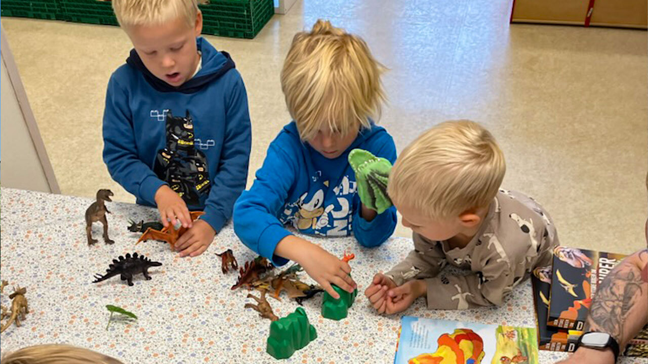 Venner som leker med dinosaurer