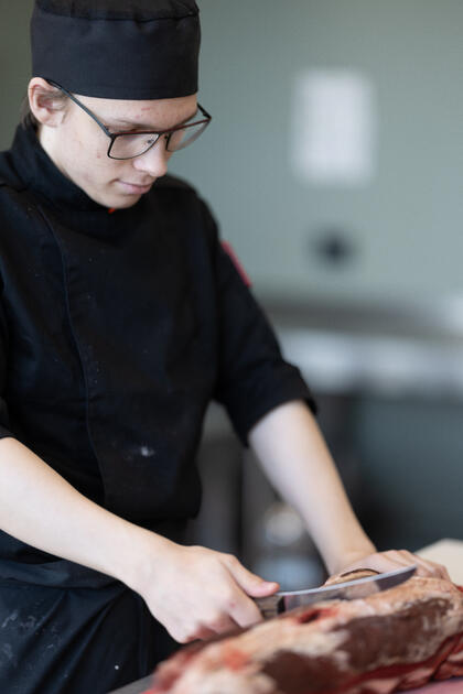 Elev skjærer kjøtt