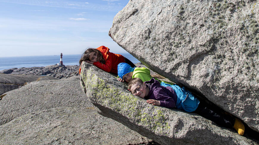 Barn som leker på fjellet ute ved Eigerøy fyr