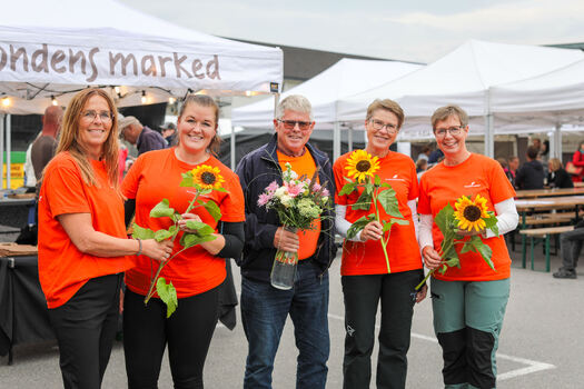 mennesker og solsikker på markedsplassen