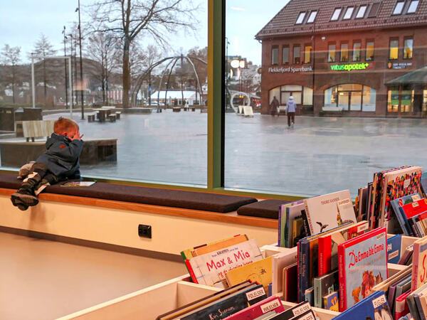 En gutt i vinduet til biblioteket