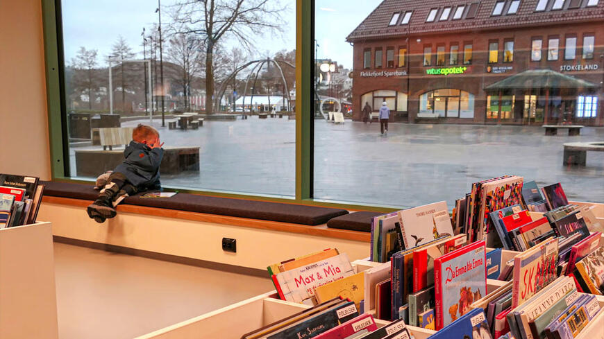 En gutt i vinduet til biblioteket