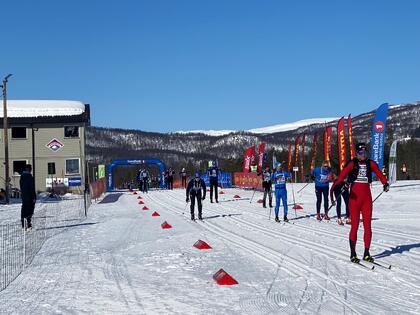 Skiløpere ved Klubbhuset på Storlømyra/ skistadion. Løpene som passerer klubbhuset ved skistadion i Bardu.