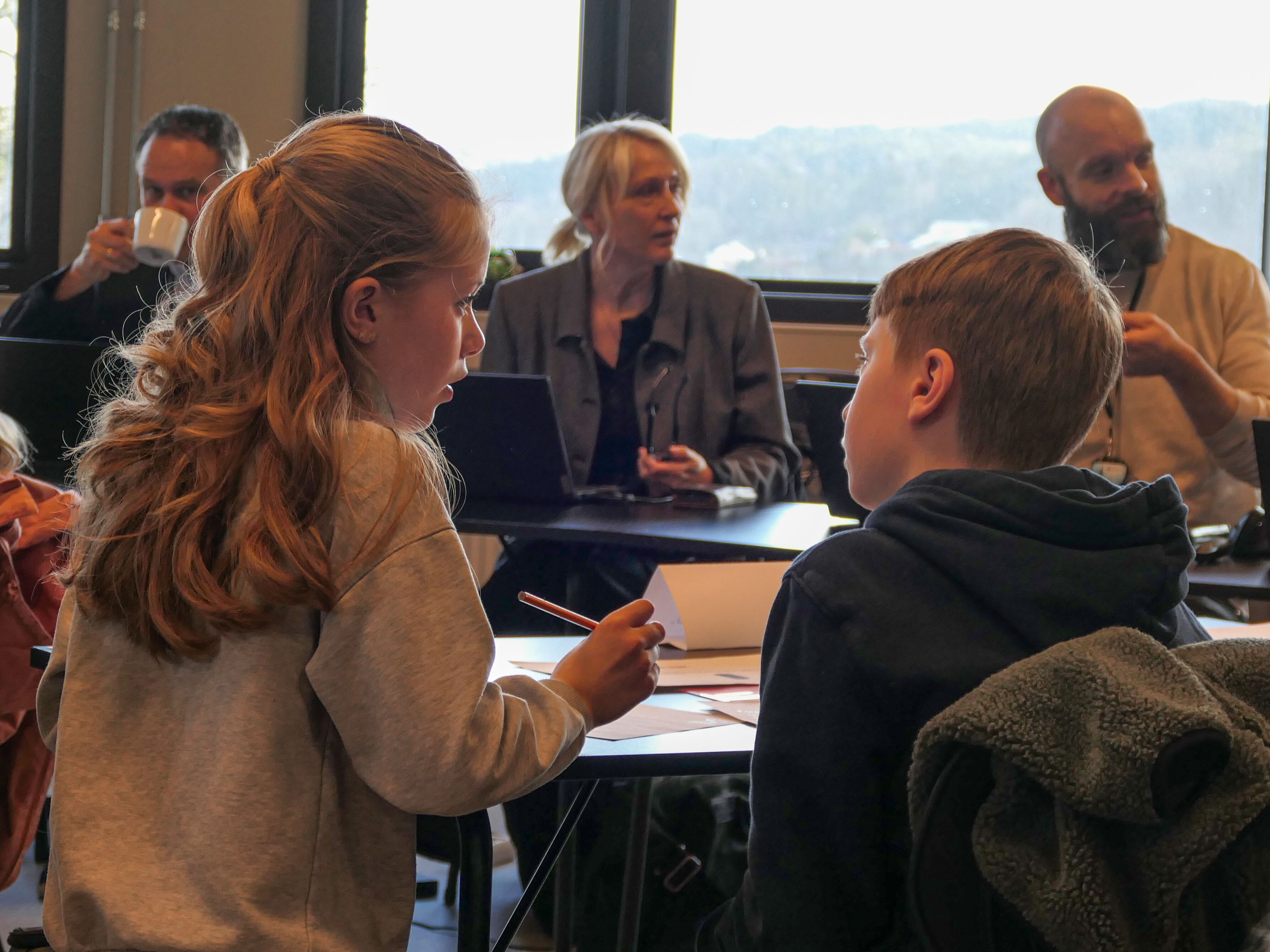 To som diskuterer ved et bord før avstemming