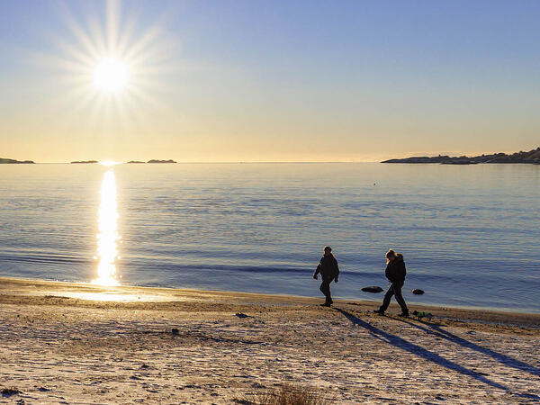 To personer som går på Skadbergsanden en vinterdag