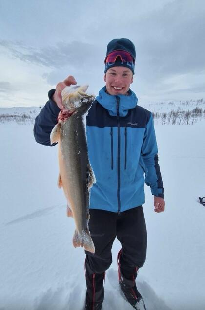 Julius på isfisketur med fisk på kroken.