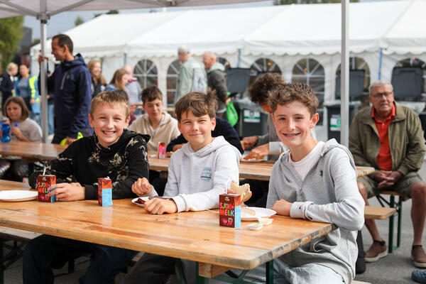 3 barn som spiser ved bord