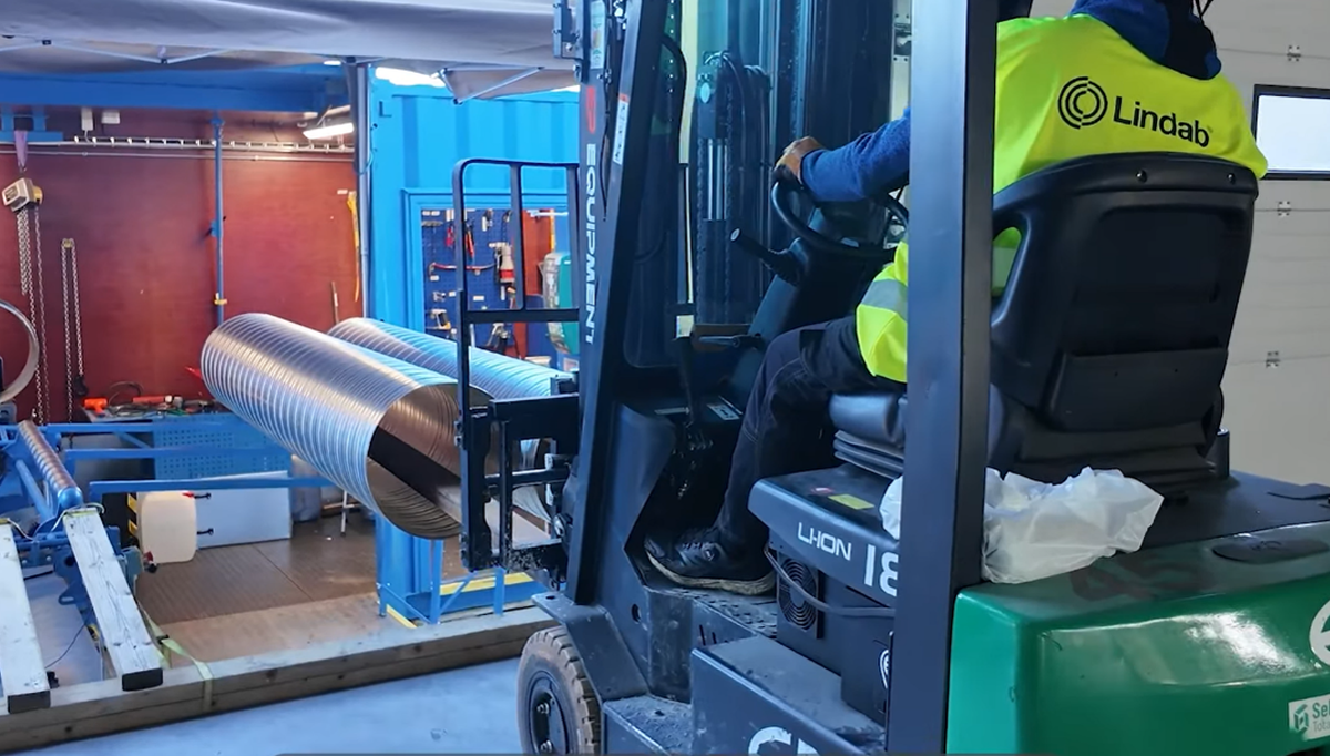 Containeren er løftet på 86 paller så den står jevnt med bygget, dermed kan trucken lett kan hente kanalene. Foto: Lindab