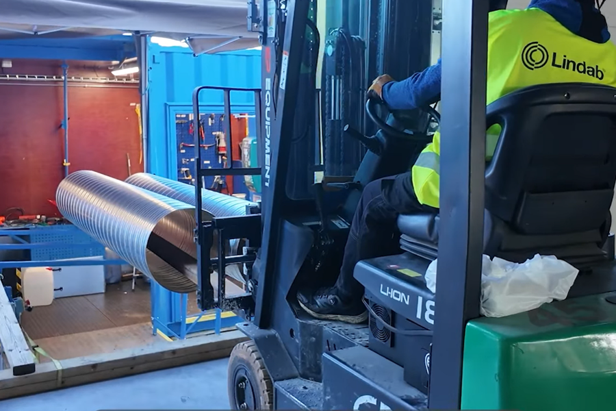 Containeren er løftet på 86 paller så den står jevnt med bygget, dermed kan trucken lett kan hente kanalene. Foto: Lindab