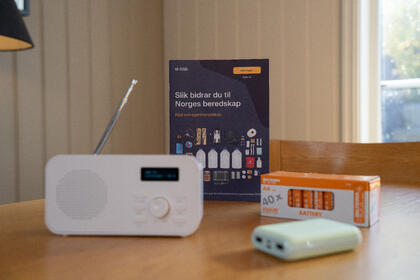 Bilde fra DSB av DAB radio, batterier og brosjyre om hvordan du bidrar til Norges beredskap.